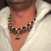 Man with a chest tattoo wearing a beaded necklace featuring white agate and dark hematite stones, paired with a cozy white fleece jacket.