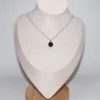 A spherical black agate crystal necklace displayed on a white jewelry mannequin bust; ideal healing crystals for anxiety and stress.