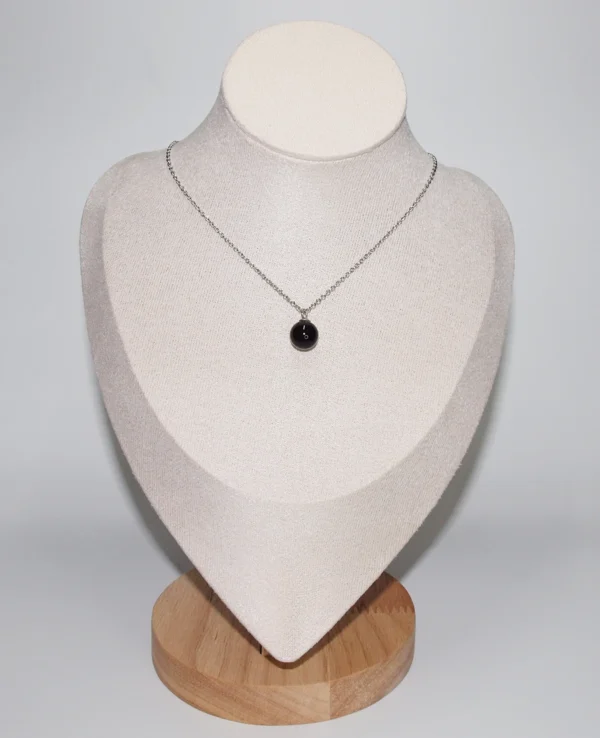 A spherical black agate crystal necklace displayed on a white jewelry mannequin bust; ideal healing crystals for anxiety and stress.