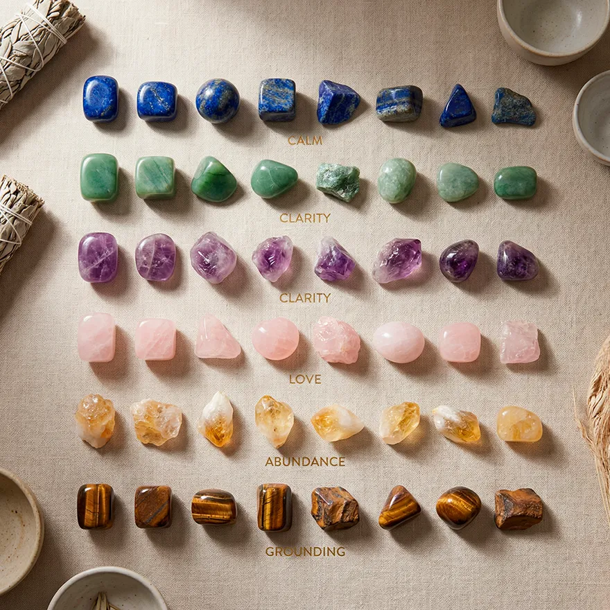 A reference guide for healing crystals categorized by properties including Calm (Lapis Lazuli), Clarity (Amethyst), Love (Rose Quartz), Abundance (Citrine), and Grounding (Tiger's Eye) on a linen background.