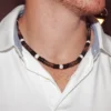 Handmade Men's Queen Conch and Coconut Shell spiritual necklace for protection and abundance, worn by a model in a clean white polo shirt, showing bead detail and fit.