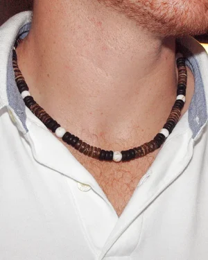 Handmade Men's Queen Conch and Coconut Shell spiritual necklace for protection and abundance, worn by a model in a clean white polo shirt, showing bead detail and fit.