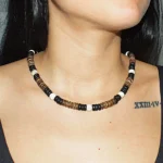 Woman wearing a handmade Queen Conch and Coconut Shell necklace featuring natural black, white and brown shell beads by GUACA-inc