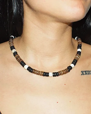Woman wearing a handmade Queen Conch and Coconut Shell necklace featuring natural black, white and brown shell beads by GUACA-inc