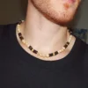 Close-up of a man wearing a handmade Trochus Shell and Coconut Beaded Necklace, showcasing the natural beach style jewelry for men's protection and well-being.