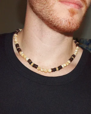 Close-up of a man wearing a handmade Trochus Shell and Coconut Beaded Necklace, showcasing the natural beach style jewelry for men's protection and well-being.