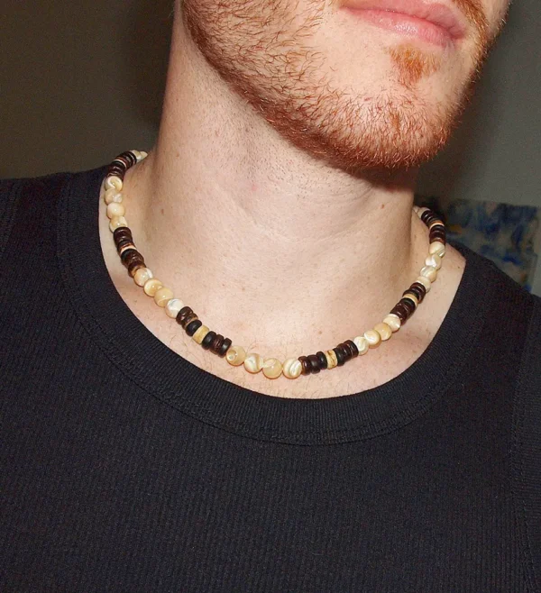 Close-up of a man wearing a handmade Trochus Shell and Coconut Beaded Necklace, showcasing the natural beach style jewelry for men's protection and well-being.