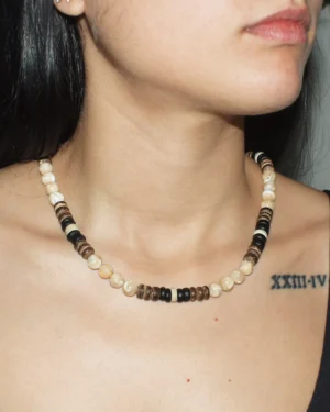 Close-up of a woman wearing a handcrafted Trochus shell and coconut shell beaded necklace.