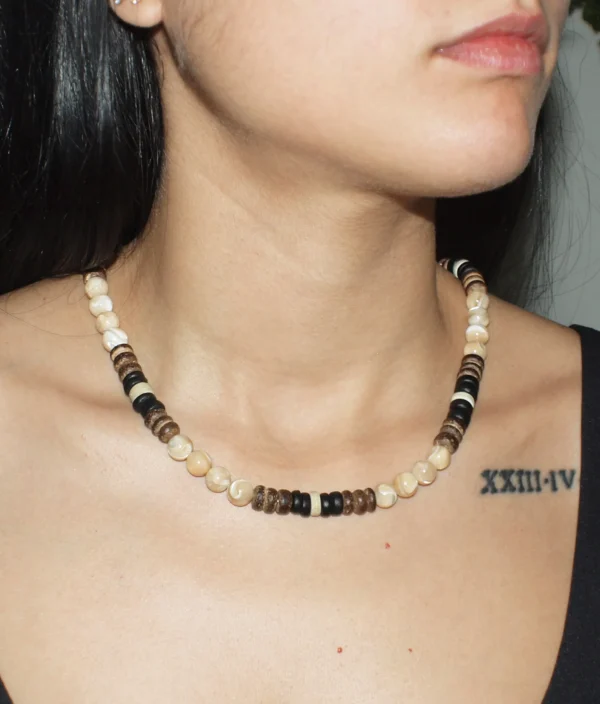 Close-up of a woman wearing a handcrafted Trochus shell and coconut shell beaded necklace.